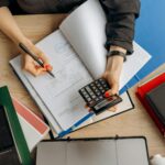 Escritorio de trabajo con ordenador y documentos financieros, representando oportunidades profesionales en finanzas y contabilidad