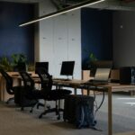 Modern office workspace with professionals collaborating around digital devices and architectural models.