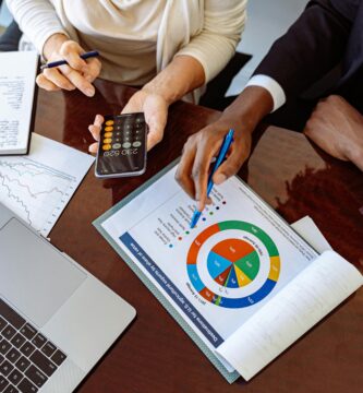 Profesionales revisando reportes financieros y gráficos en oficina, concepto de empleos en finanzas y contabilidad con crecimiento profesional y estabilidad laboral