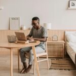 Persona trabajando en un ordenador portátil mientras busca empleo hoy