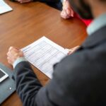 Persona analizando documentación de seguro de coche antes de contratar cobertura adecuada