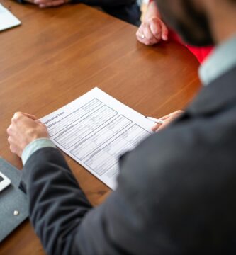 Persona analizando documentación de seguro de coche antes de contratar cobertura adecuada